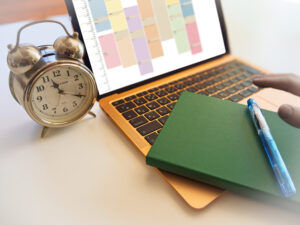 ノートパソコンと目覚まし時計、ノート、万年筆の画像